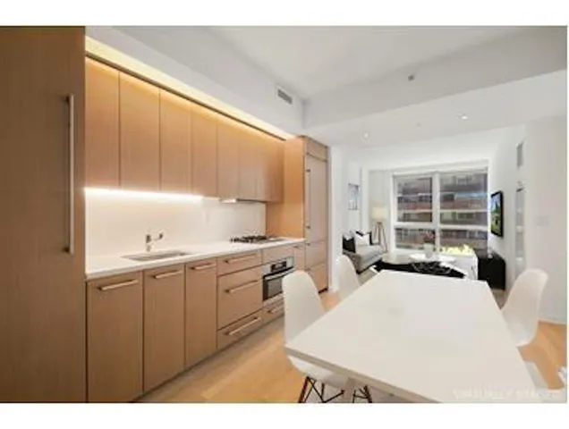 a large white kitchen with kitchen island a sink a stove and a refrigerator