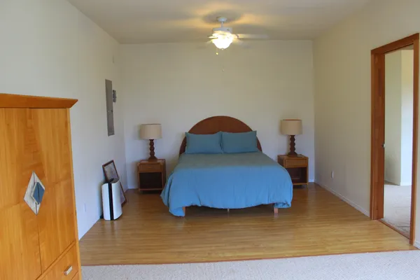a bedroom with a bed and wooden floor