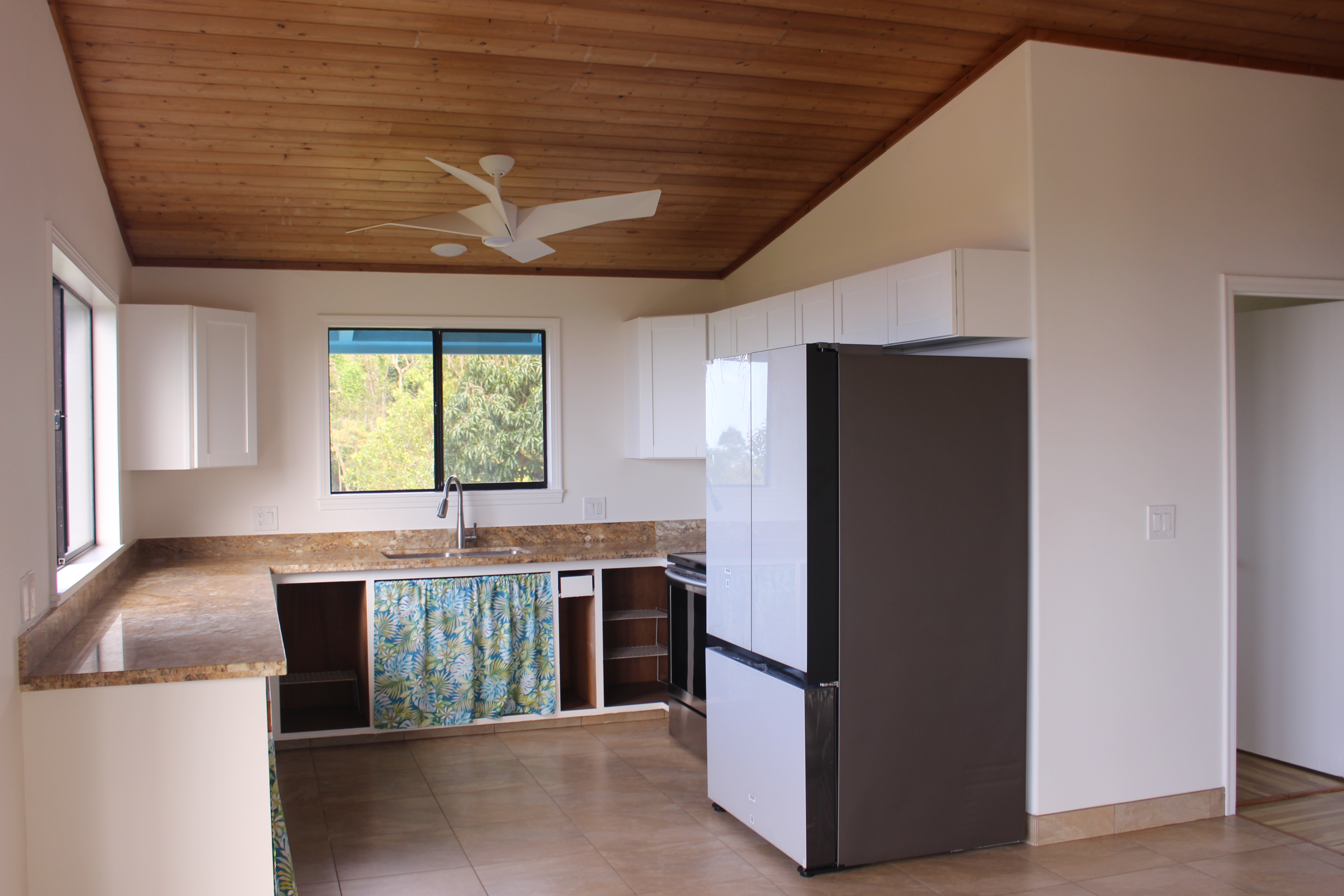 83-5477 Hawaiʻi Belt Road Captain Cook, HI 96704 - Photo 23 of 30 a kitchen with kitchen island a counter top space a sink stainless steel appliances and cabinets