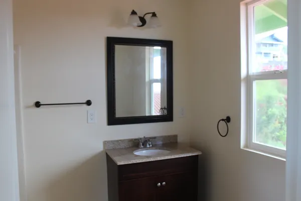 a bathroom with a toilet sink vanity and mirror