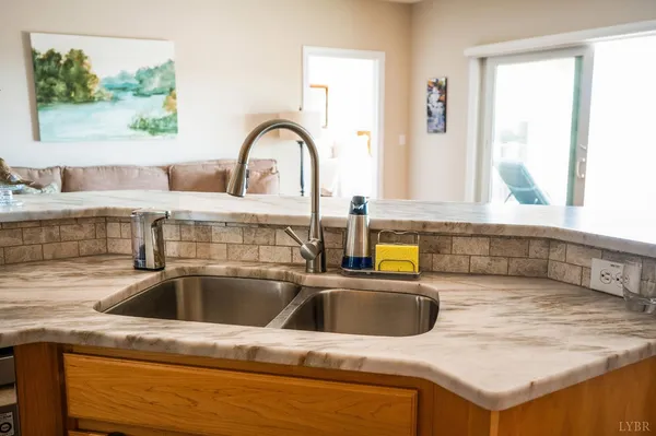 a kitchen with granite countertop a sink a stove and cabinets