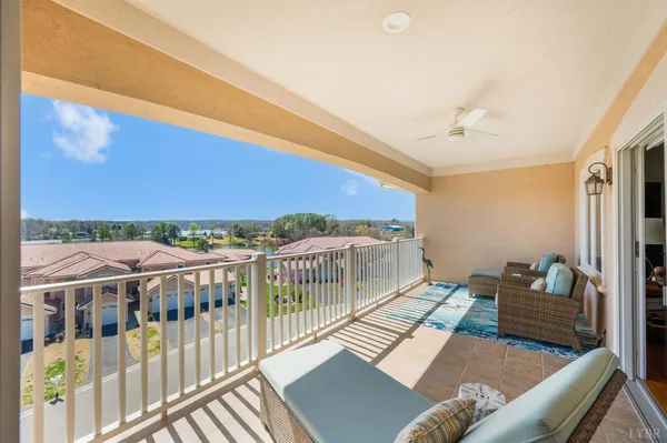 a balcony with furniture and a floor to ceiling window
