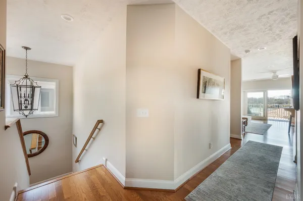 a view of a hallway with front door and wooden floor