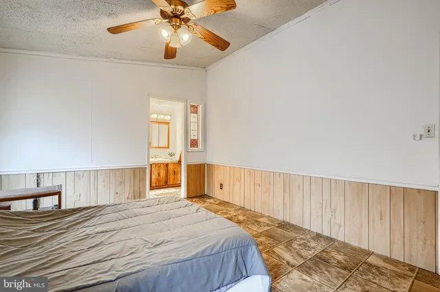 a spacious bedroom with a bed and a chandelier