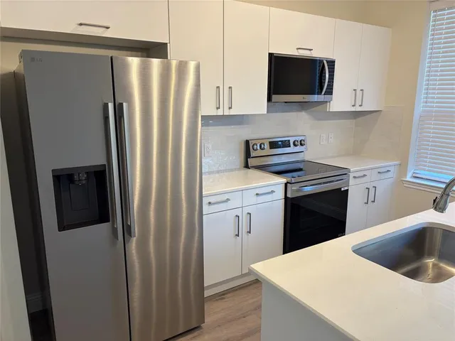 a kitchen with a refrigerator stove and sink