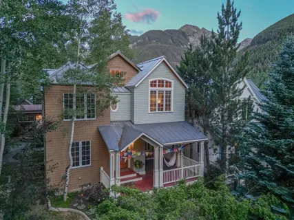 a aerial view of a house with a yard and large trees