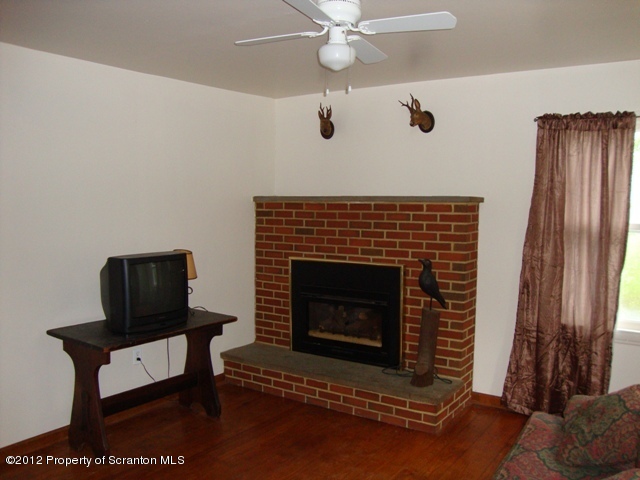 1270 State Rte 3011 Meshoppen, PA 18630 - Photo 3 of 20 a living room with furniture a flat screen tv and a fireplace