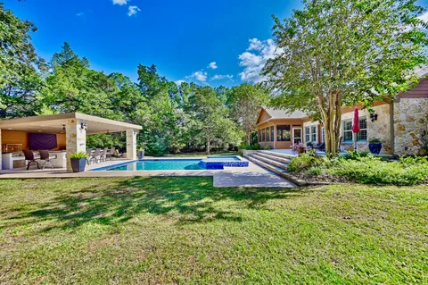 a house view with swimming pool and garden space