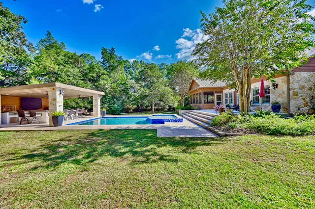 a house view with swimming pool and garden space