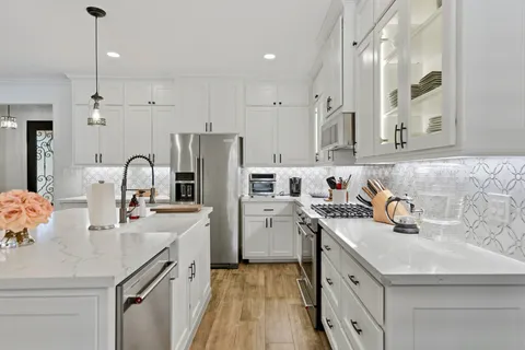a view of a dining room and livingroom with furniture wooden floor a chandelier
