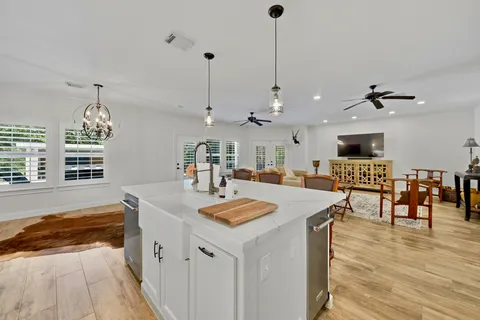 a open kitchen with stainless steel appliances granite countertop a sink a stove a dining table and chairs
