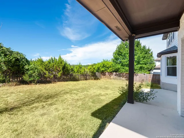 a view of a house with backyard and sitting area
