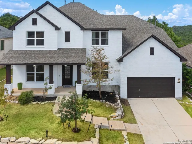 a aerial view of a house with a small yard plants and large tree