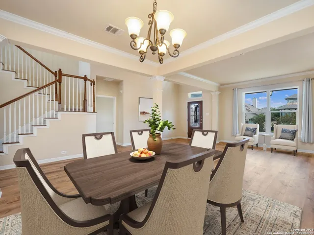 a dining room with furniture a chandelier and wooden floor