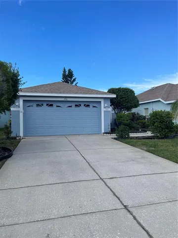 a front view of a house with a yard and mountain view