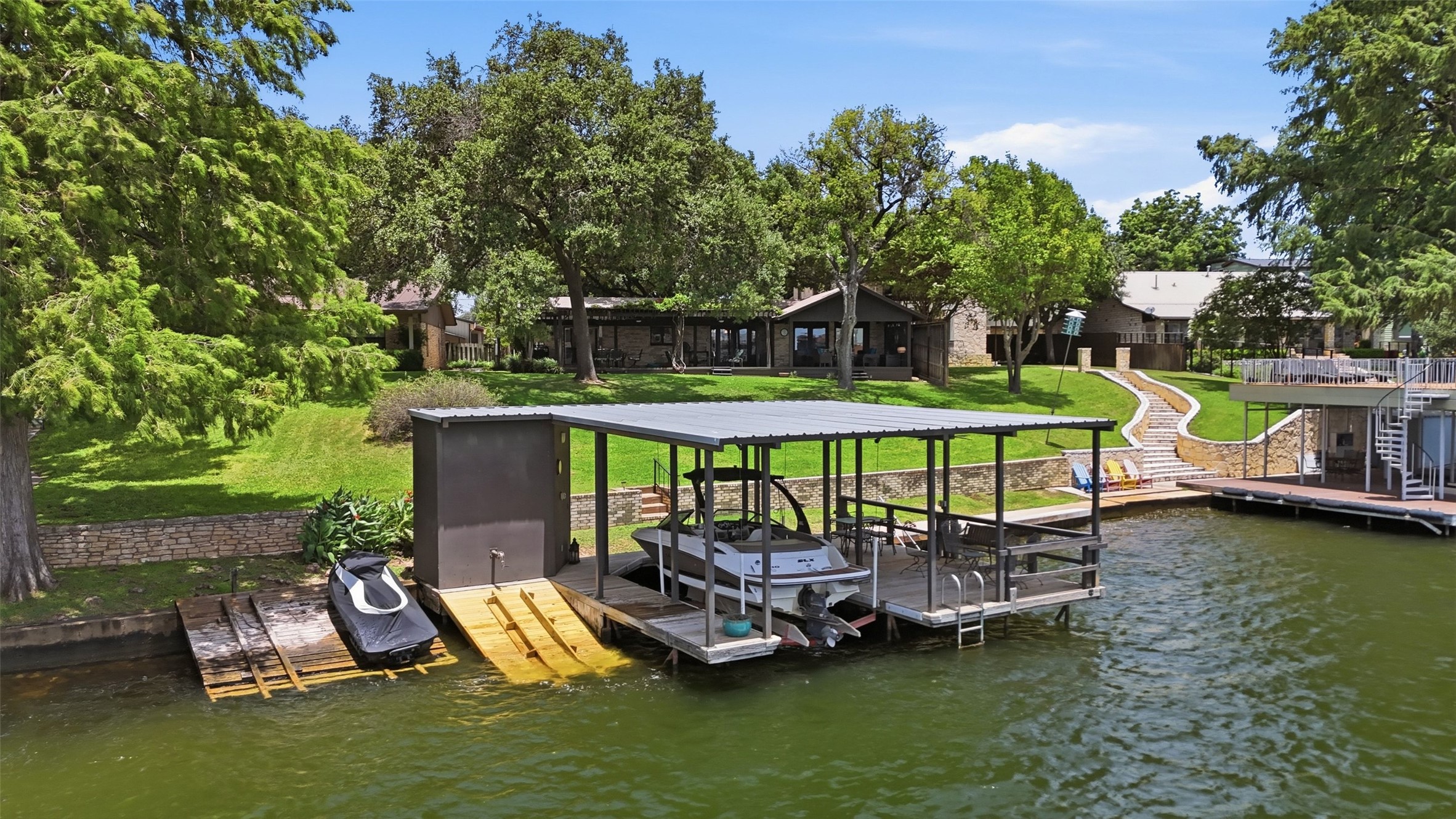141 Perry Lane Kingsland, TX 78639 - Photo 6 of 40 Lakeside oasis features a private boat dock, dual boat lifts, and lush, landscaped grounds leading to the water.