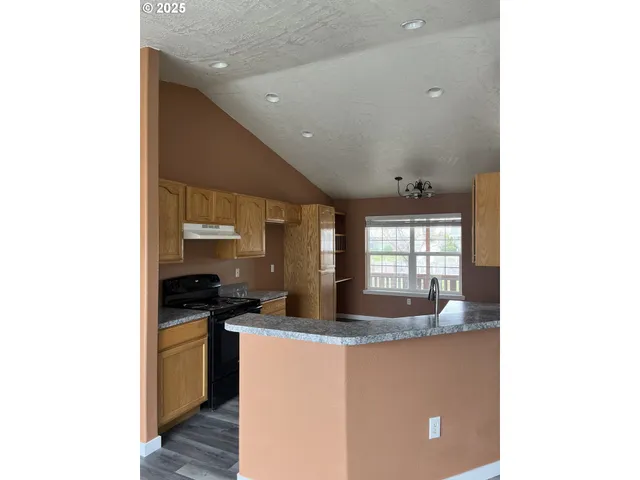 a kitchen with granite countertop a sink and a stove