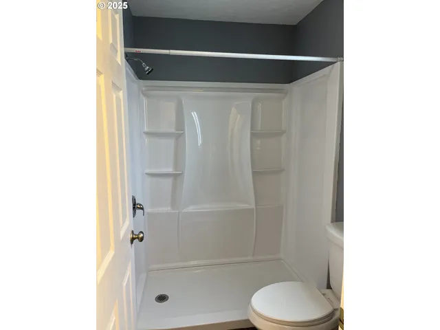 a bathroom with a toilet and a shower