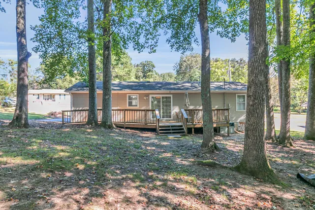a view of a house with backyard and a tree