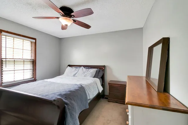 a bedroom with a bed and a flat tv screen on dresser