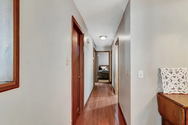 a view of a hallway with wooden floor and staircase