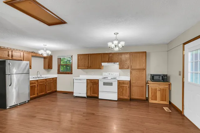 a kitchen with a refrigerator and a stove top oven