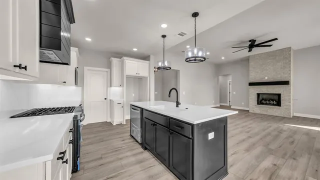 a kitchen with kitchen island a sink appliances and cabinets