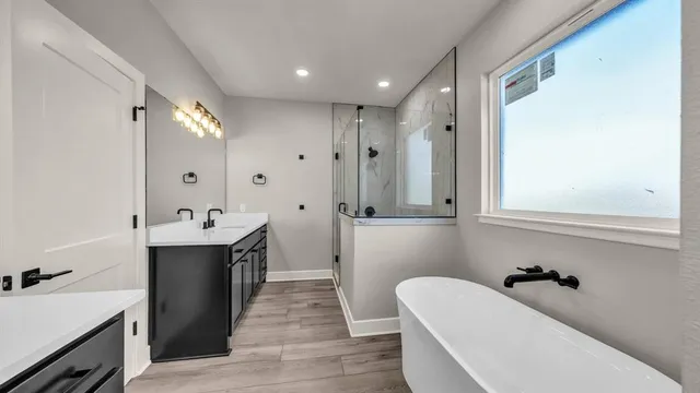 a bathroom with a tub sink and mirror
