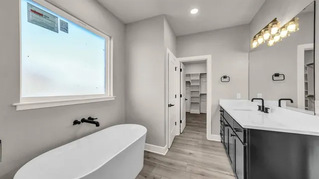 a bathroom with a tub sink and mirror