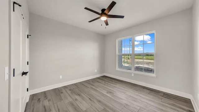 a view of wooden floor and a chandelier fan in a room