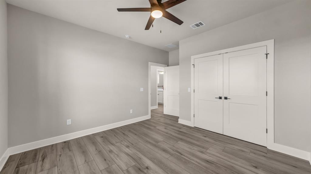 151 County Road 2610 Decatur, TX 76234 - Photo 31 of 38 Unfurnished bedroom with wood finished floors, a closet, and a ceiling fan