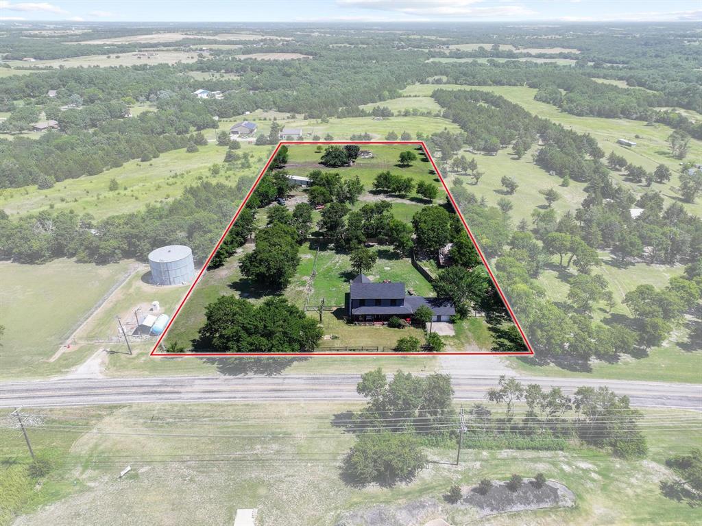 4453 Farm To Market 902 Howe, TX 75459 - Photo 17 of 40 Expansive property featuring a black-roofed residence, mature trees, and a defined boundary line