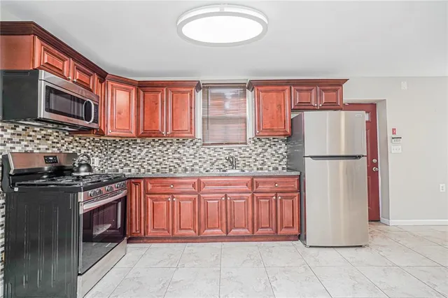 a kitchen with stainless steel appliances granite countertop a refrigerator and a stove top oven