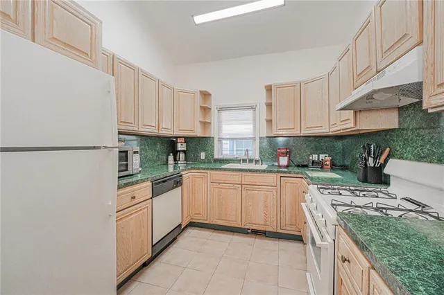 a kitchen with stainless steel appliances granite countertop a sink stove and cabinets
