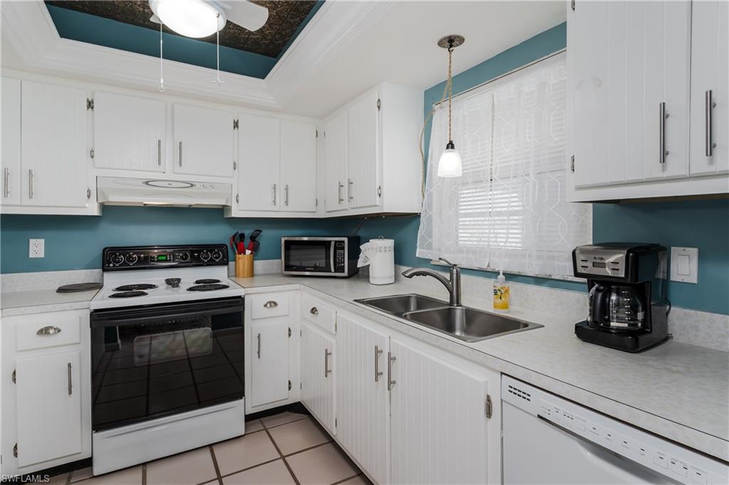 5419 Rattlesnake Hammock Road, Unit 307F Naples, FL 34113 - Photo 7 of 22 a kitchen with white cabinets and white appliances