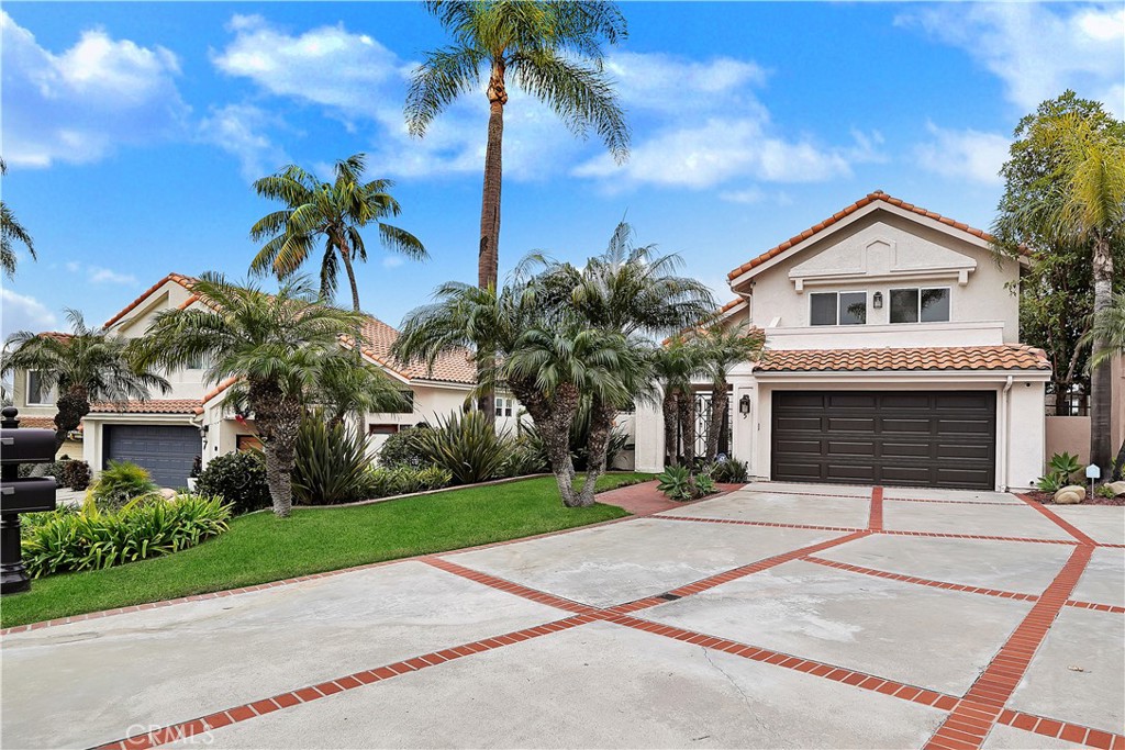 a front view of a house with a yard and palm trees