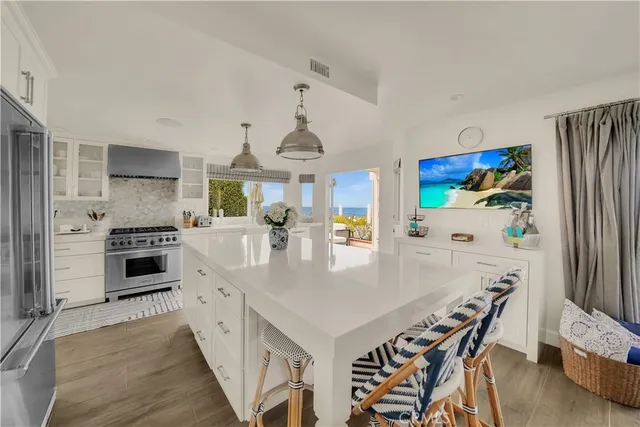 a kitchen with stainless steel appliances a stove a table and chairs