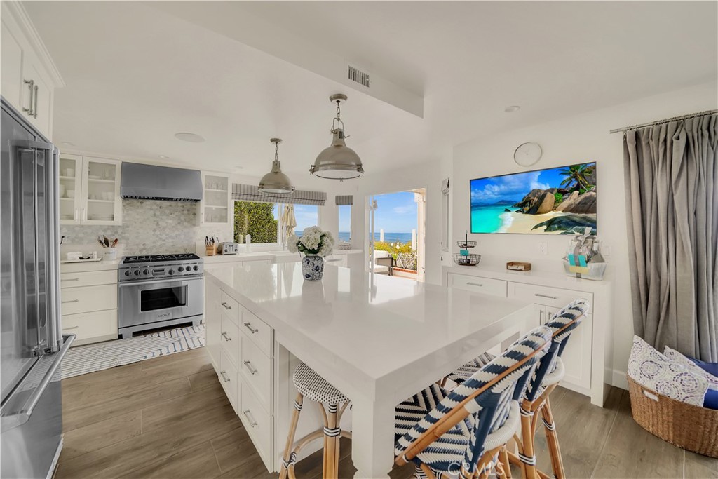 5 Regatta Way Dana Point, CA 92629 - Photo 13 of 32 a kitchen with stainless steel appliances a stove a table and chairs