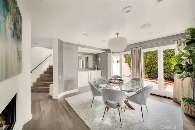 a dining room with wooden floor a chandelier a wooden table and chairs