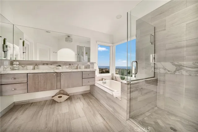 a large white bathroom with a double vanity sink a mirror and a shower