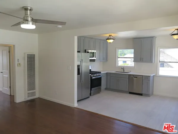 a kitchen with a refrigerator and a stove top oven