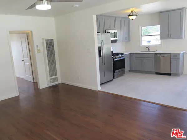 a kitchen with granite countertop a refrigerator and a sink
