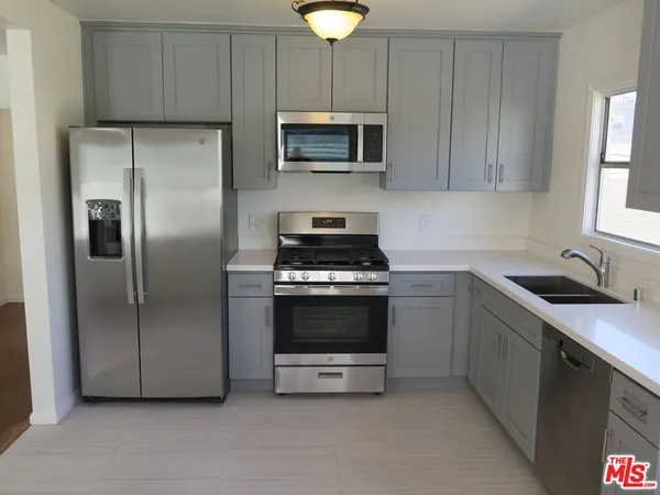 a kitchen with cabinets stainless steel appliances and a sink