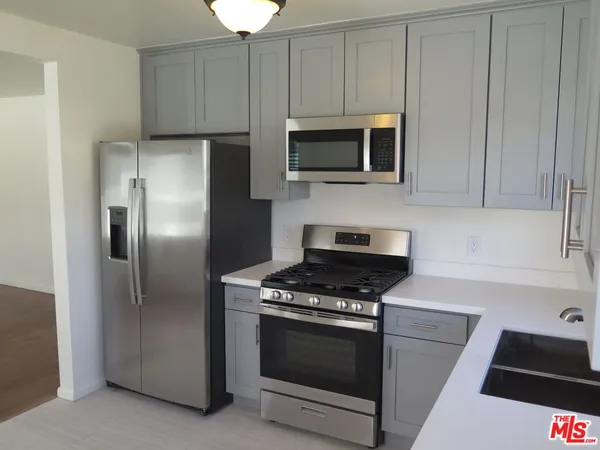 a kitchen with white cabinets and stainless steel appliances