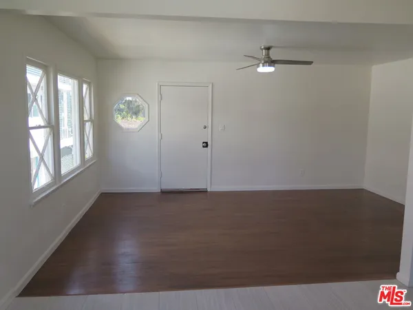 an empty room with windows and cabinet