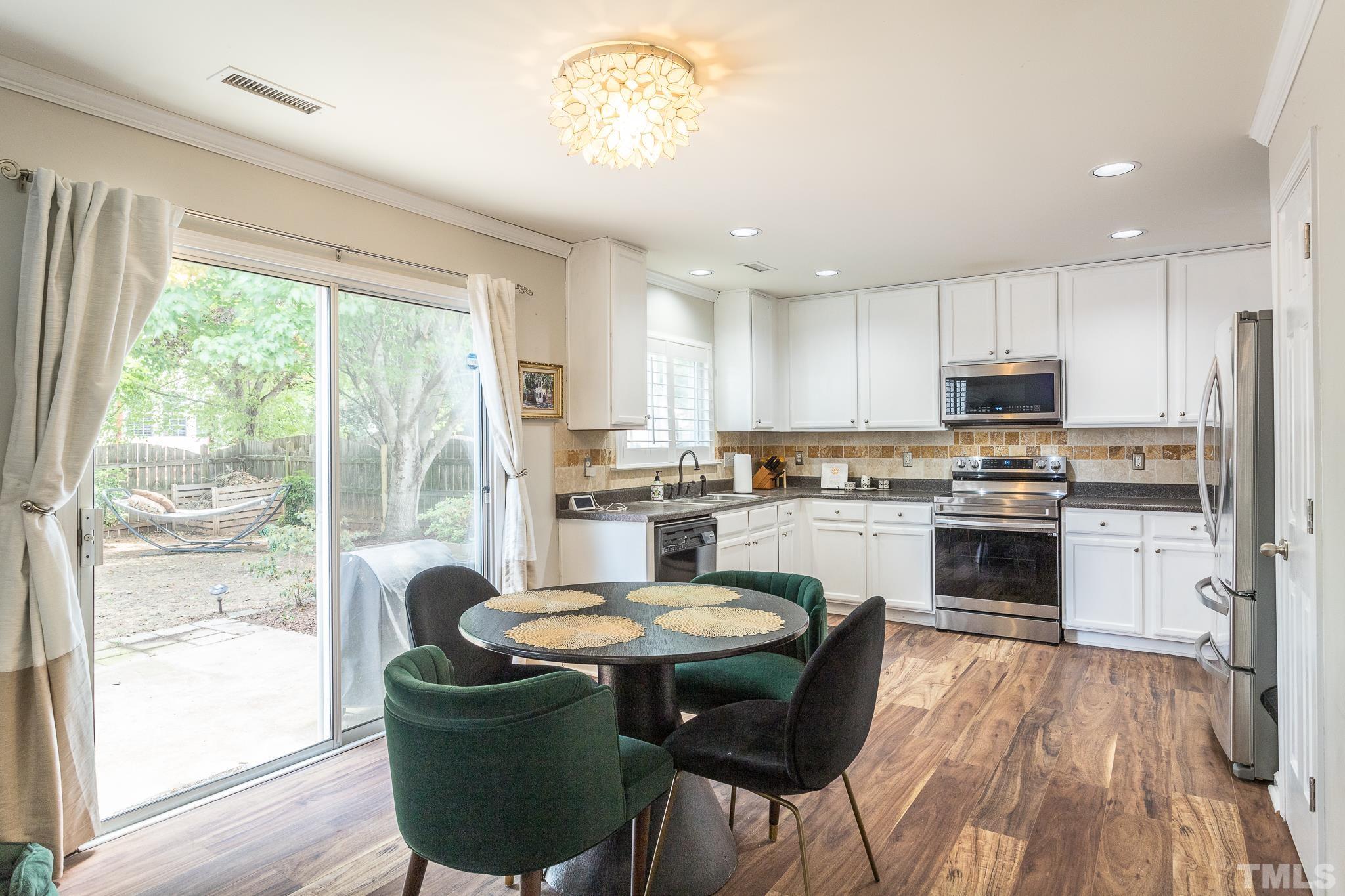 128 Ryder Cup Circle Raleigh, NC 27603 - Photo 8 of 30 a kitchen with a dining table chairs and refrigerator
