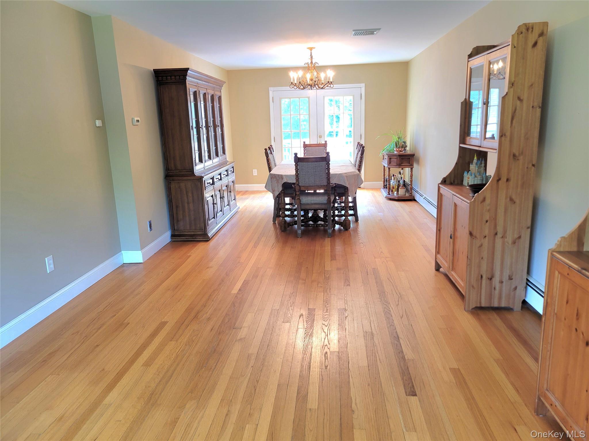 46 Cortlandt Road Mahopac, NY 10541 - Photo 11 of 36 Hardwood flooring extending throughout, neutral wall paint, white trim, and a chandelier light fixture
