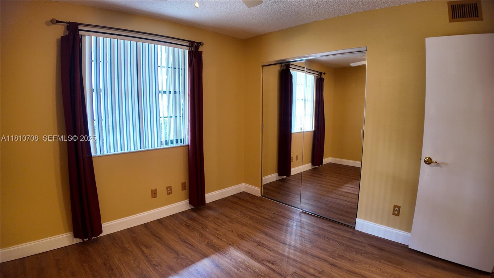 9577 West McNab Road, Unit 110 Tamarac, FL 33321 - Photo 15 of 38 an empty room with wooden floor and closet