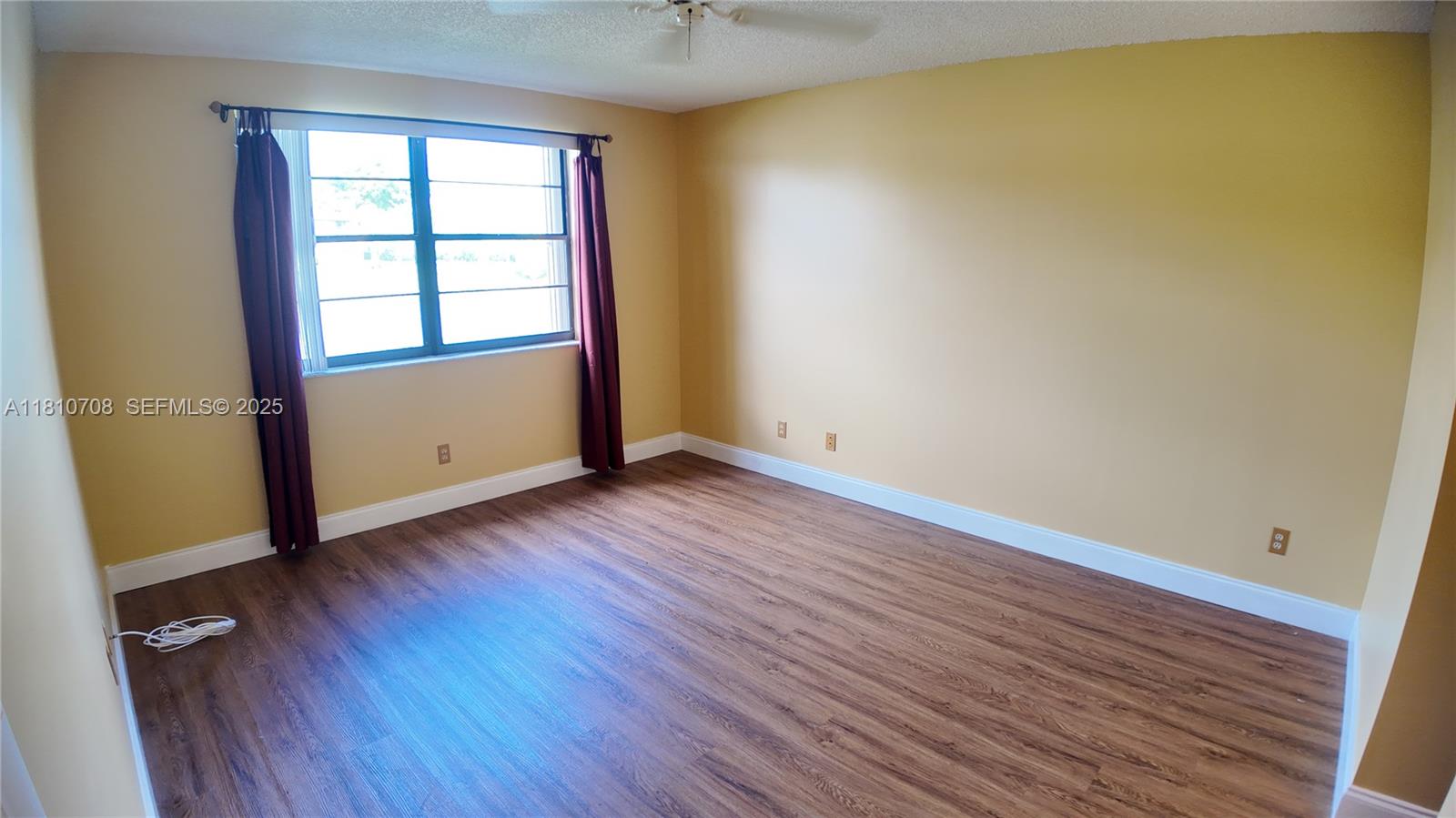 9577 West McNab Road, Unit 110 Tamarac, FL 33321 - Photo 20 of 38 an empty room with wooden floor and windows