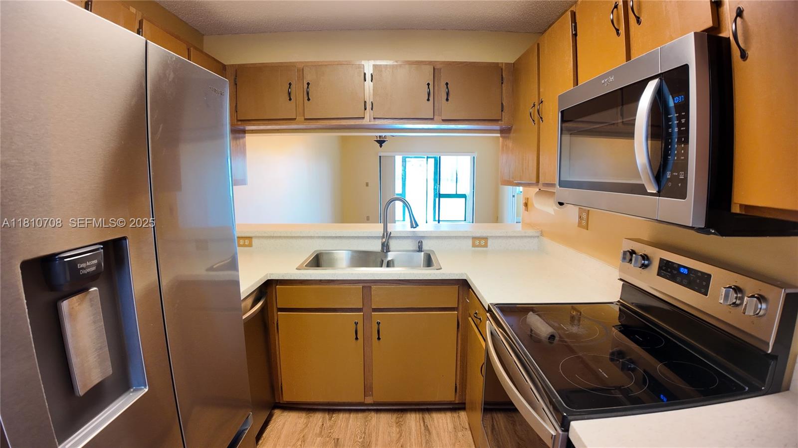 9577 West McNab Road, Unit 110 Tamarac, FL 33321 - Photo 8 of 38 a kitchen with a stove microwave and sink